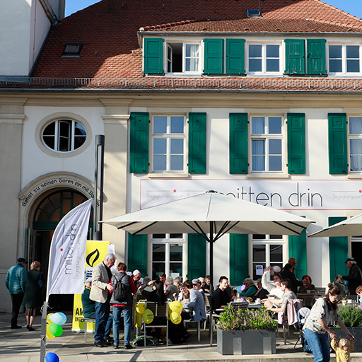Menschen genießen sonnigen Tag im Straßencafé