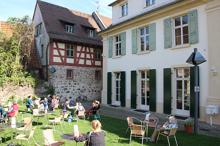 Menschen genießen sonnigen Tag im Gartencafé