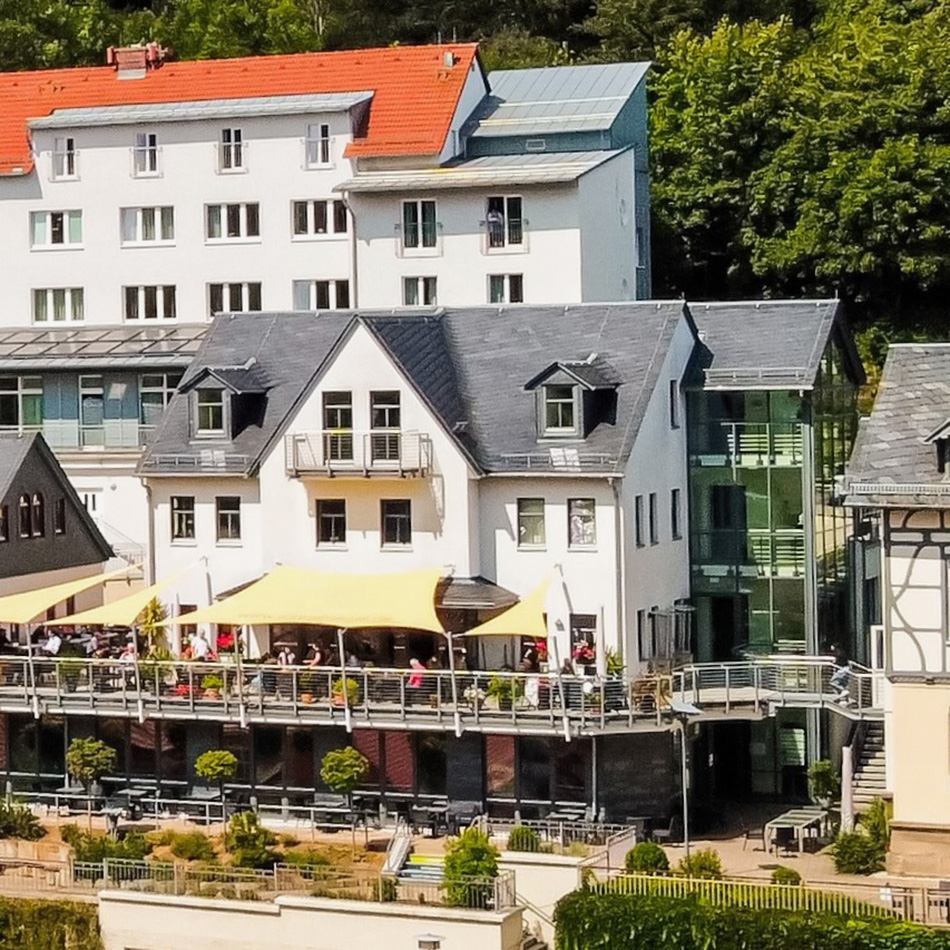 Außenansicht eines Hotels mit Terrasse und Bäumen