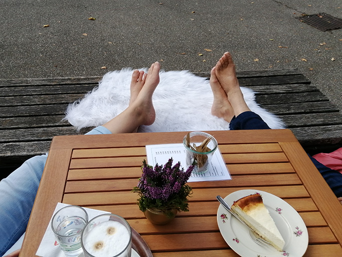 Zwei Personen entspannen im Freien mit Kaffee.