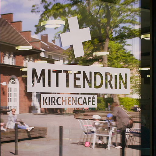 Mittendrin Kirchenkafé Schild in urbaner Umgebung