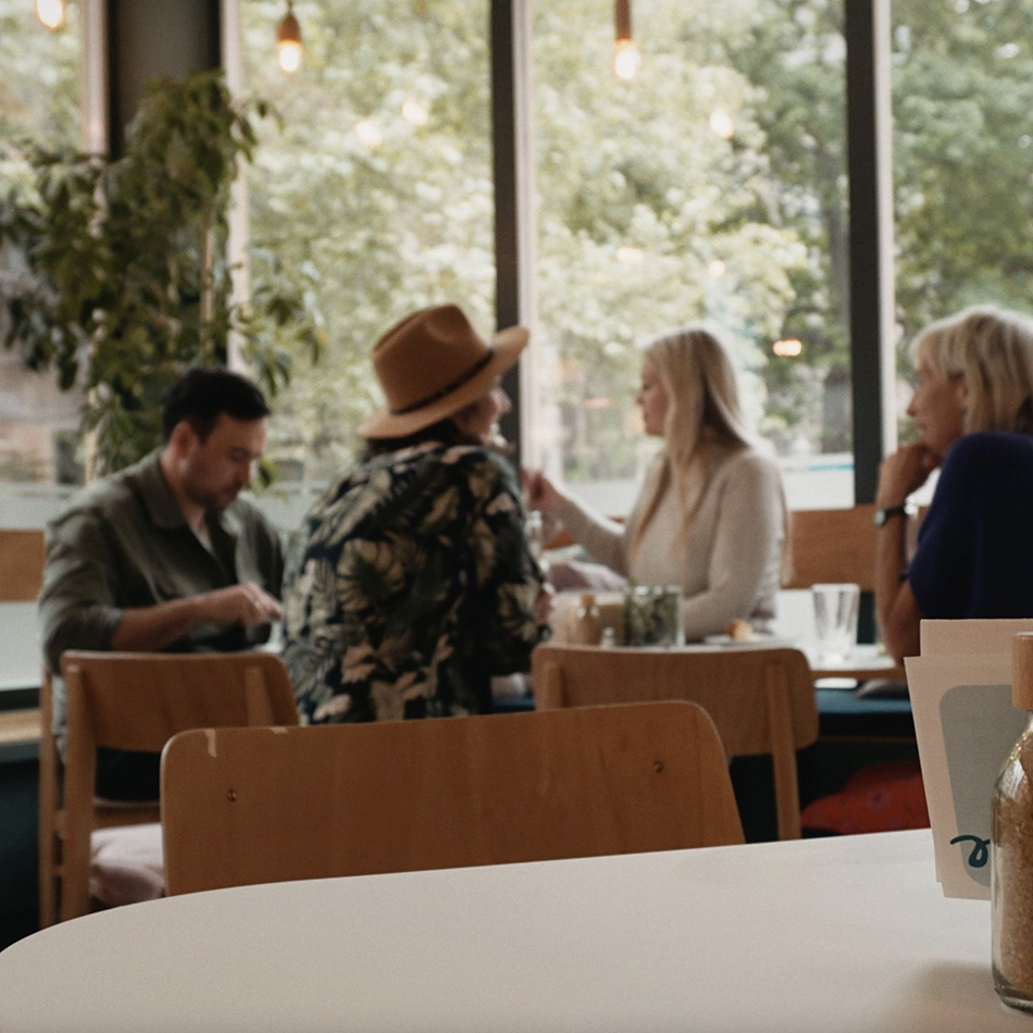 Vier Personen unterhalten sich in einem gemütlichen Café.