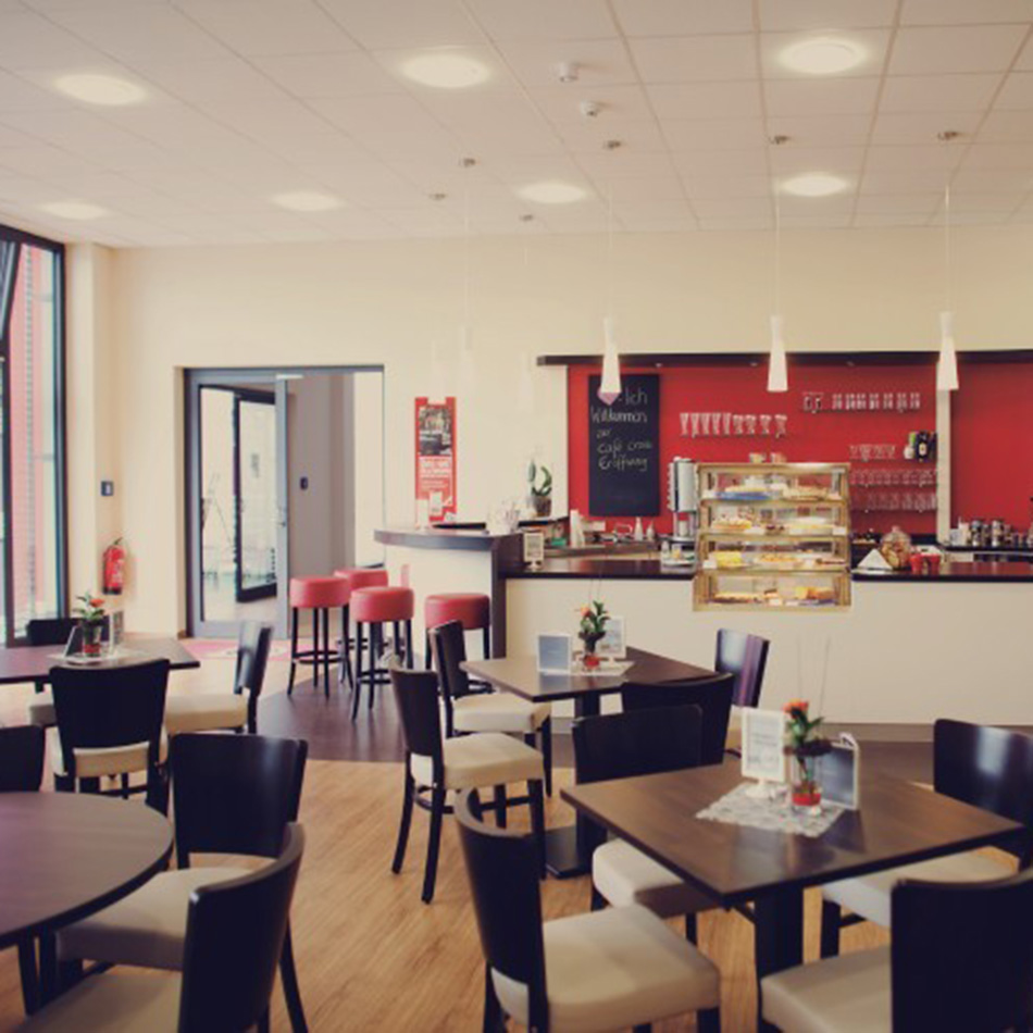 Gemütliches Café mit modernen Sitzgelegenheiten und Tresen.