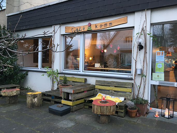 Gemütliches Café mit Holzdeko und Sitzgelegenheiten draußen