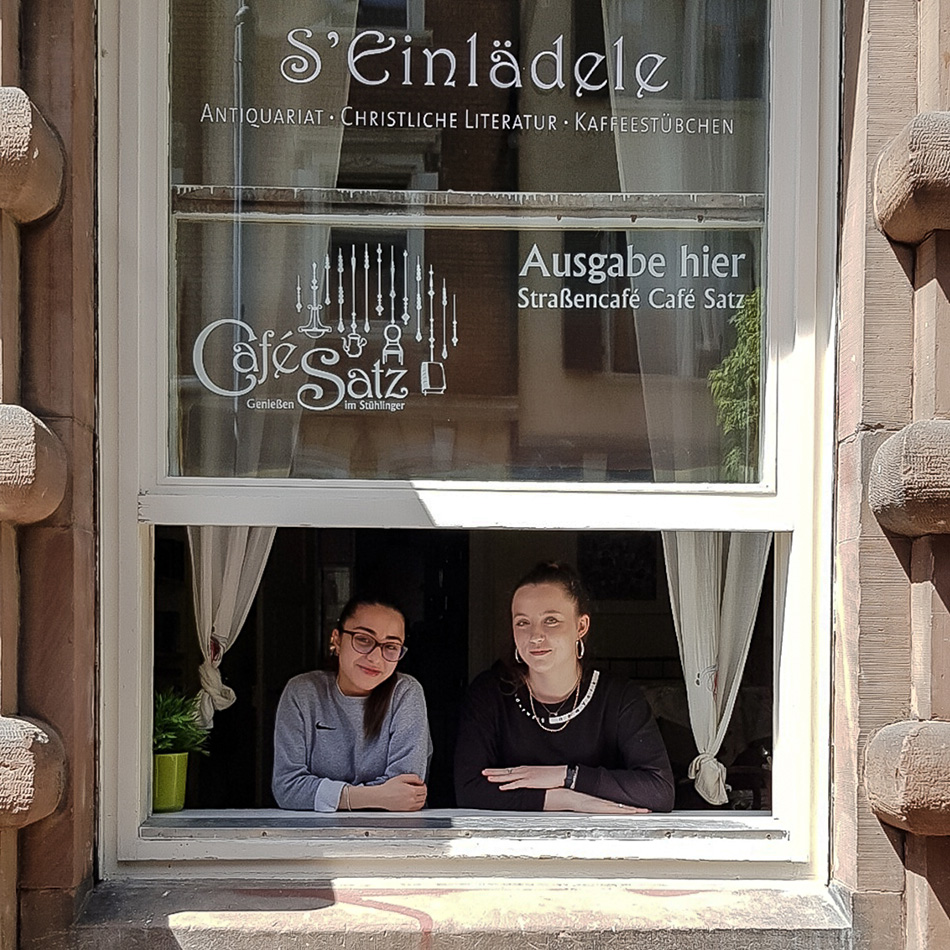 Frauen im Caféfenster in der Sonne sitzend