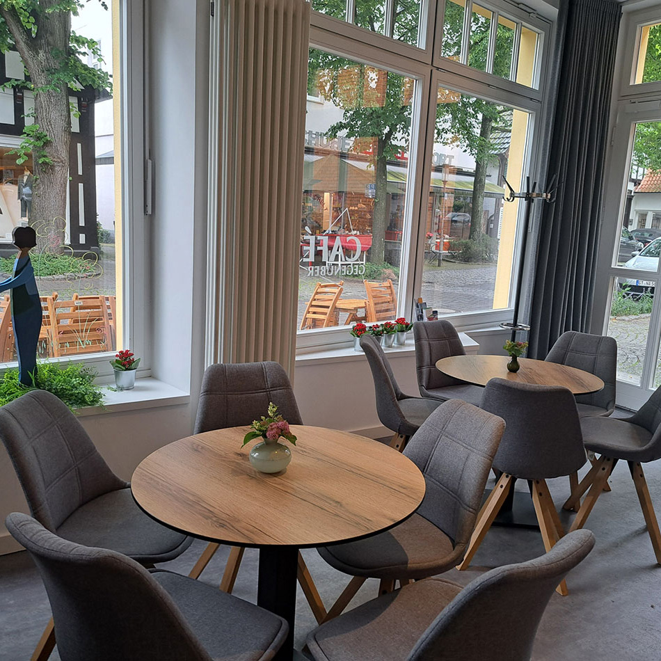 Gemütliches Café mit Holz- und Graustühlen innen