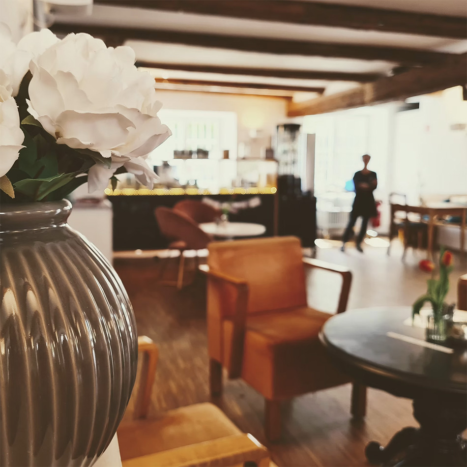 Gemütliches Café mit bequemen Stühlen und Blumen.